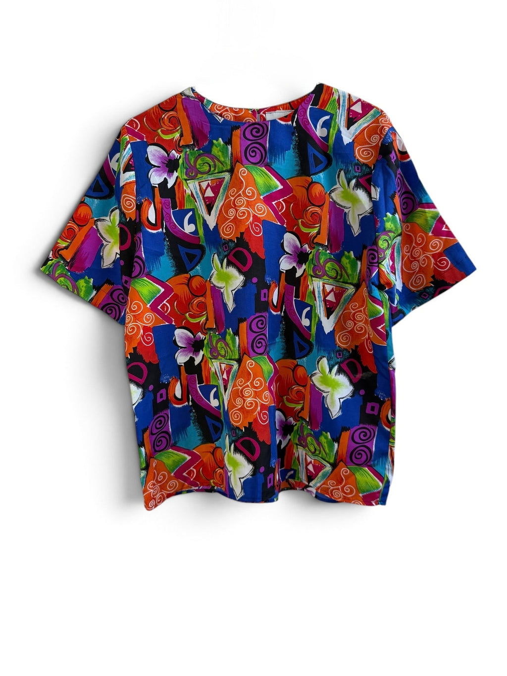 A short-sleeve crewneck t-shirt featuring a vibrant, multicolored abstract pattern with geometric shapes and stylized floral elements in red, blue, green, purple, orange, and yellow, displayed flat against a white background.